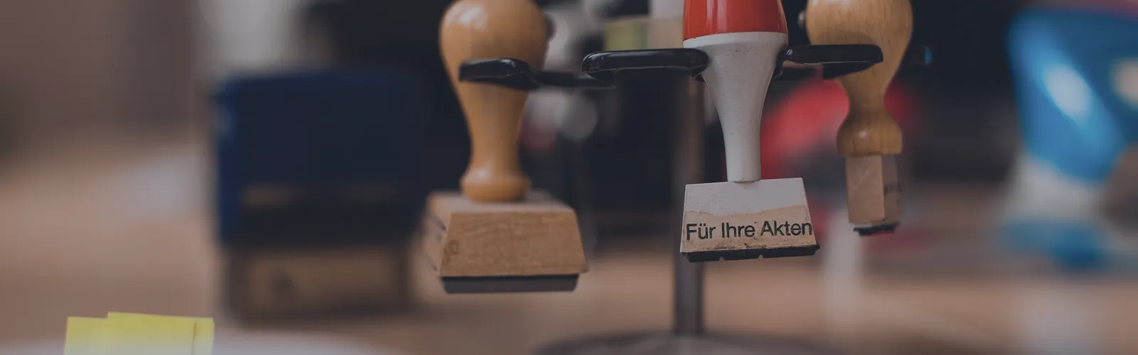 Rubber stamps lined up on their stand at the front of a desk