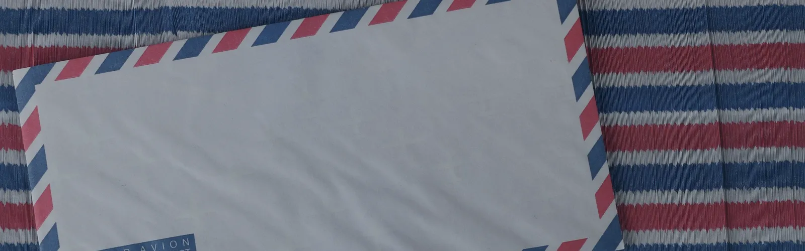 Blank airmail envelope on a striped background