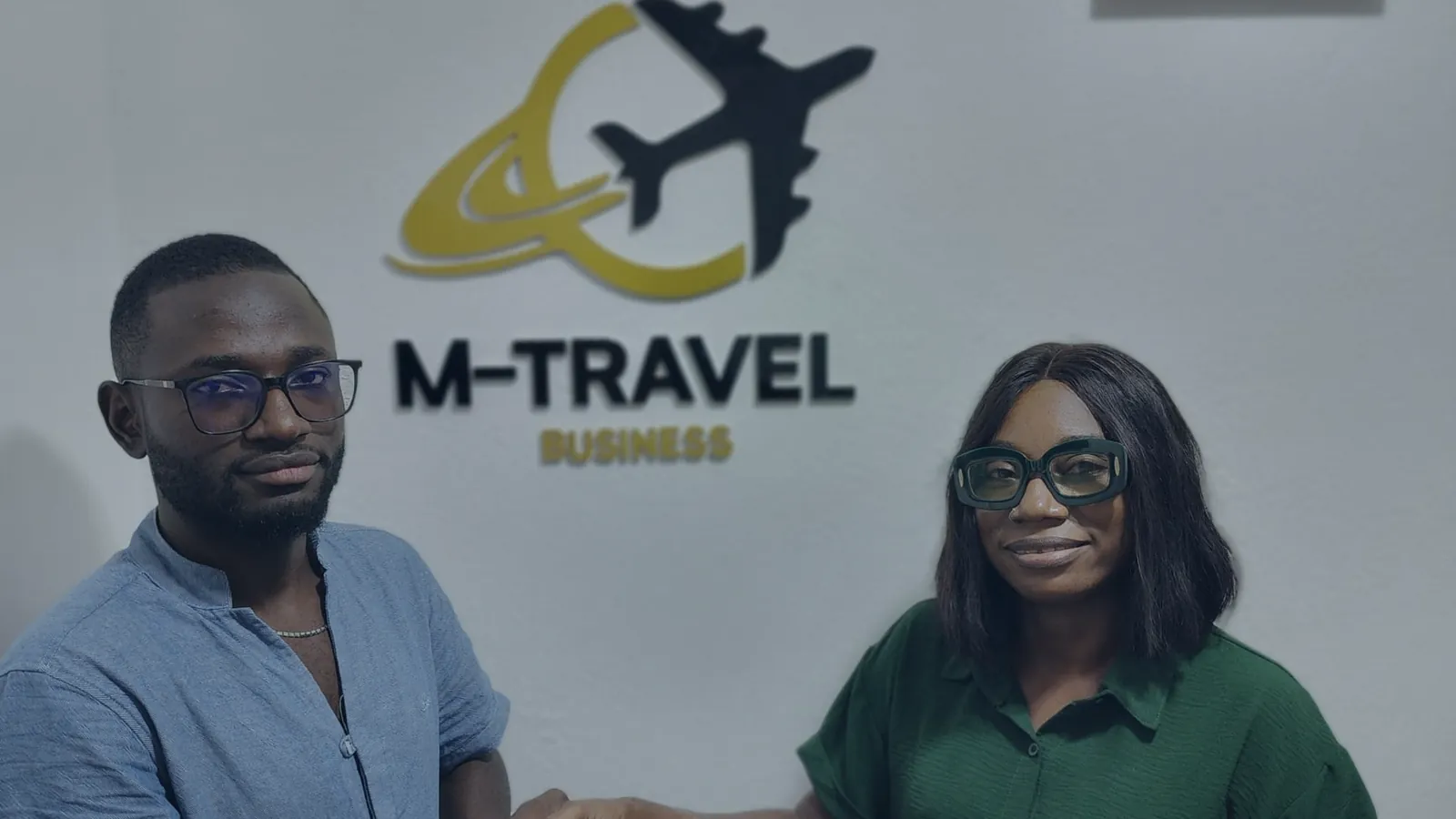 Makazung Ndieffouo Georgette Viviane et Makazung Cyrille au bureau de Japoma, devant le logo de M-Travel, partenaire de Verbatim